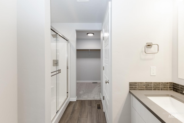 bathroom featuring vanity, an enclosed shower, and hardwood / wood-style floors