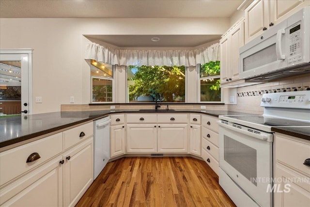 2920 S Givens Way, Meridian, ID 83642 - kitchen featuring white appliances, a sink, light wood-style floors, decorative backsplash, and dark countertops