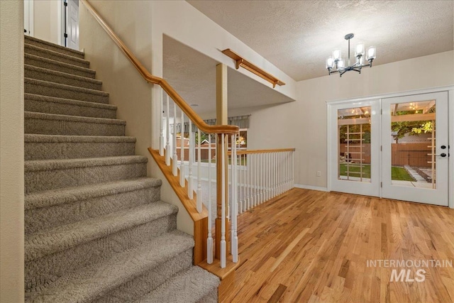 2920 S Givens Way, Meridian, ID 83642 - stairway featuring a chandelier, wood finished floors, baseboards, and a textured ceiling