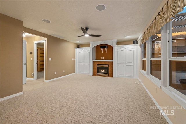 2920 S Givens Way, Meridian, ID 83642 - unfurnished living room with ceiling fan, a textured ceiling, carpet flooring, baseboards, and a fireplace with flush hearth