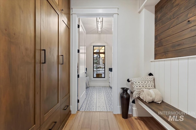 mudroom featuring wood walls