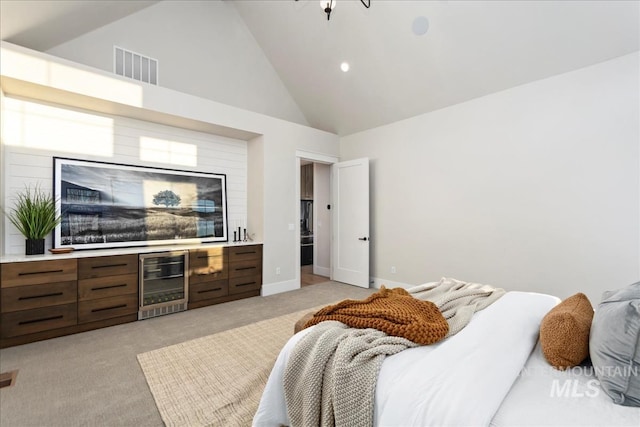 bedroom featuring visible vents, high vaulted ceiling, baseboards, beverage cooler, and light carpet