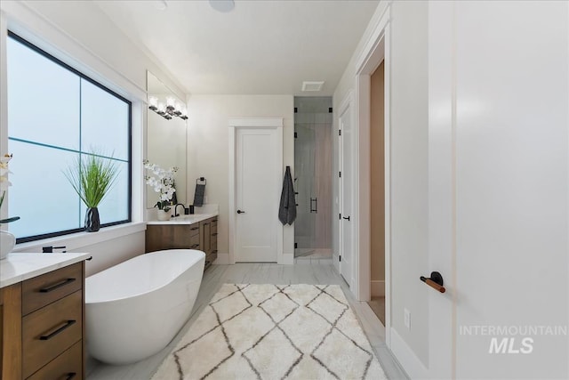 full bath with vanity, marble finish floor, a shower stall, visible vents, and a soaking tub