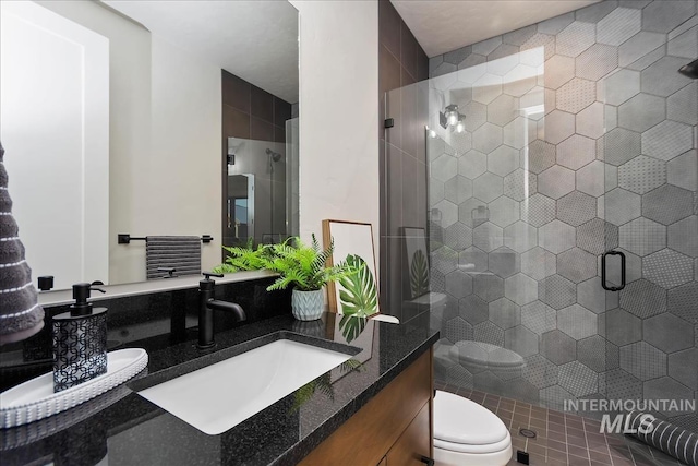 bathroom with vanity, a stall shower, and toilet