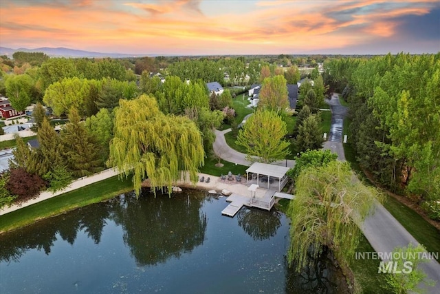 aerial view at dusk featuring a water view