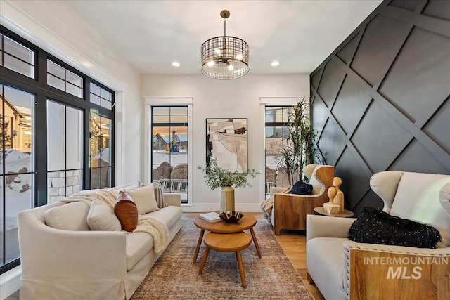 sitting room with an inviting chandelier, recessed lighting, baseboards, and wood finished floors