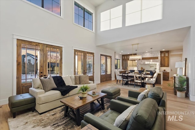 living area featuring a high ceiling, french doors, and light wood finished floors