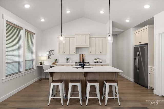 1866 W Windswept Dr, Meridian, ID 83646 - kitchen with stainless steel refrigerator with ice dispenser, lofted ceiling, a kitchen bar, light countertops, and backsplash