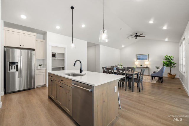 1866 W Windswept Dr, Meridian, ID 83646 - kitchen featuring appliances with stainless steel finishes, ceiling fan, light countertops, lofted ceiling, and light wood-type flooring
