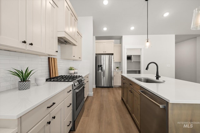 1866 W Windswept Dr, Meridian, ID 83646 - kitchen featuring stainless steel appliances, wood finished floors, decorative backsplash, light countertops, and pendant lighting