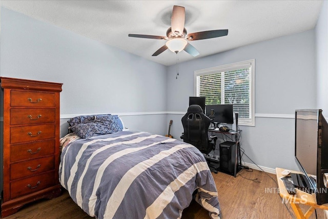 bedroom featuring dark wood-style floors, ceiling fan, and baseboards