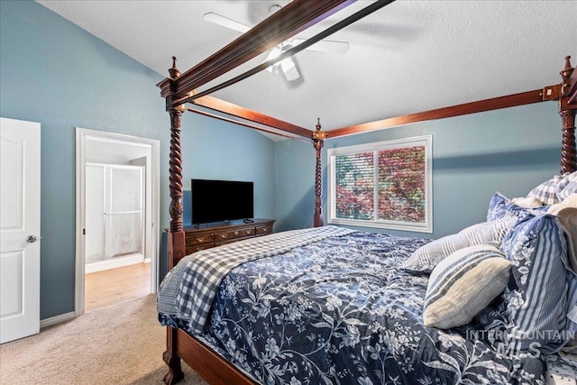 carpeted bedroom featuring a ceiling fan, ensuite bath, and vaulted ceiling