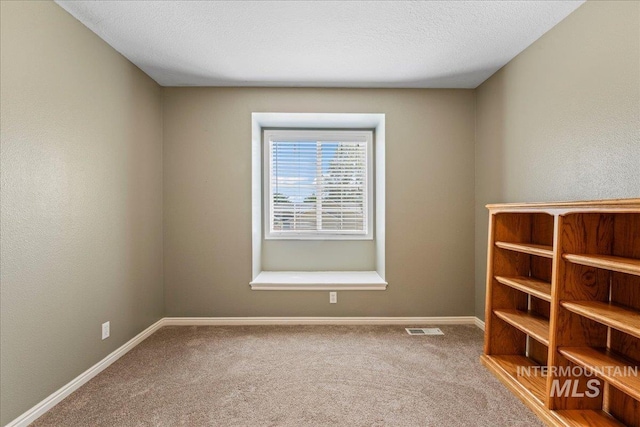 empty room featuring carpet flooring and baseboards