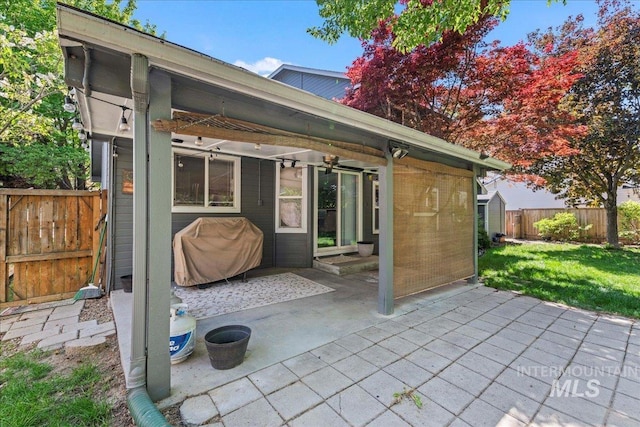 view of patio featuring ceiling fan, a grill, and a shed