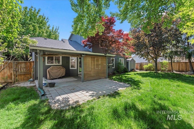 back of property with a patio area, a shed, an outbuilding, and a gate
