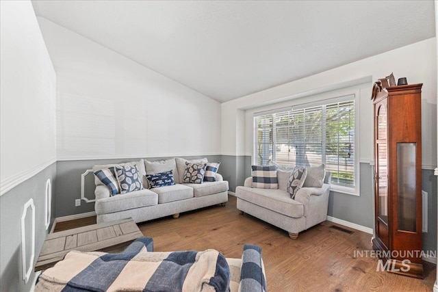 living room featuring wood finished floors, high vaulted ceiling, and baseboards