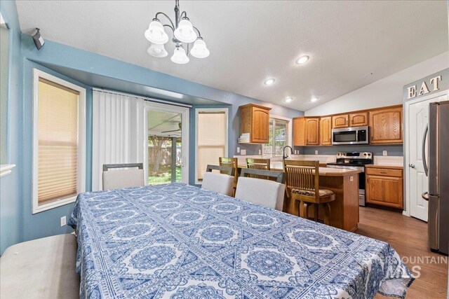 dining space featuring a chandelier, lofted ceiling, dark wood finished floors, and recessed lighting