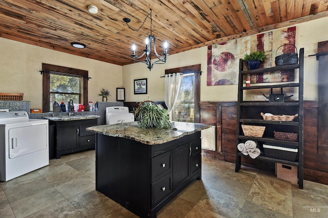 kitchen with wood ceiling, light stone counters, decorative light fixtures, plenty of natural light, and washer / clothes dryer