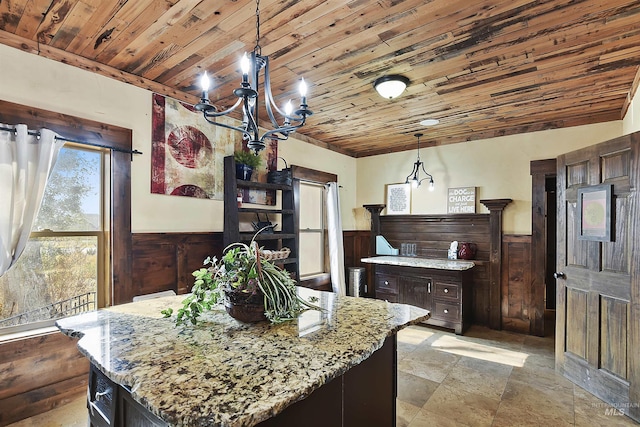 kitchen featuring dark brown cabinetry, decorative light fixtures, wooden ceiling, and a kitchen island