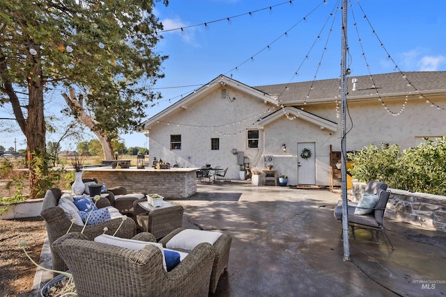 back of property featuring an outdoor living space and a patio area