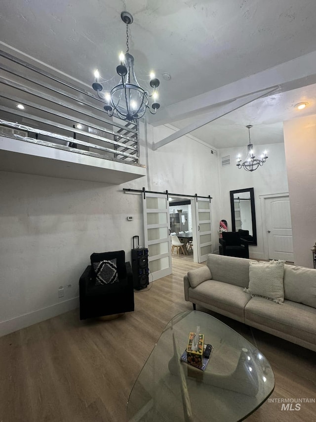 living room featuring hardwood / wood-style flooring, a barn door, and a chandelier