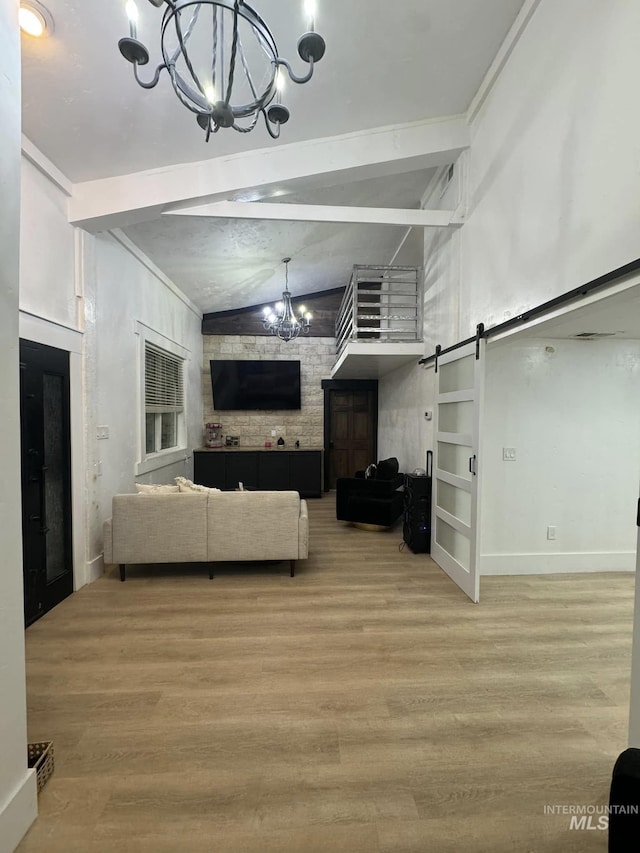 living room featuring hardwood / wood-style flooring, a barn door, and a chandelier