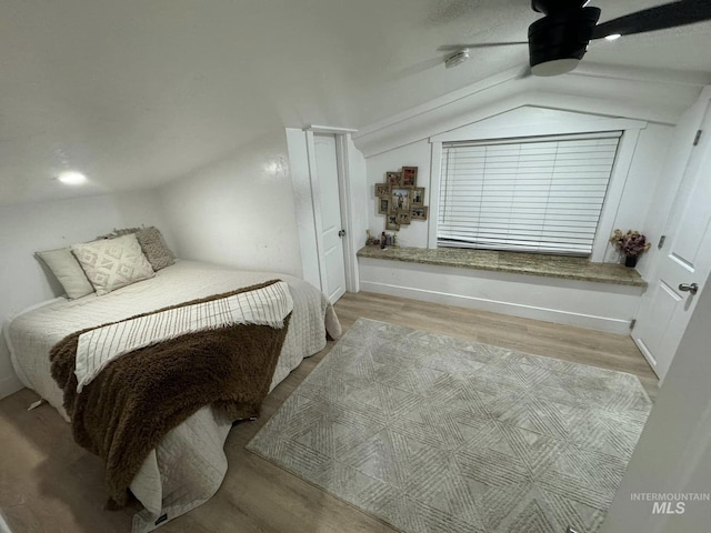 bedroom with ceiling fan, lofted ceiling, and light wood-type flooring