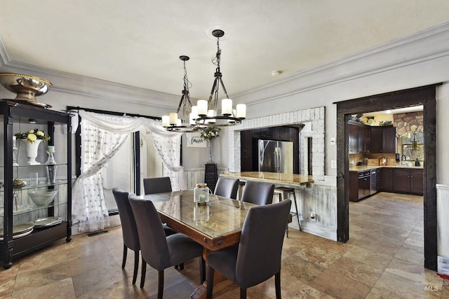 dining space with ornamental molding, sink, and a notable chandelier