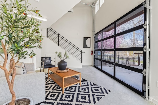 3472 N Prospect Ln, Garden City, ID 83714 - living room featuring a towering ceiling, baseboards, finished concrete floors, and stairs