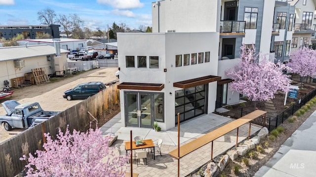 3472 N Prospect Ln, Garden City, ID 83714 - rear view of house with stucco siding, fence, french doors, a residential view, and a wall mounted air conditioner