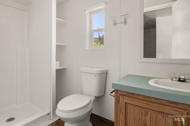 full bathroom with a stall shower, toilet, vanity, and wood finished floors
