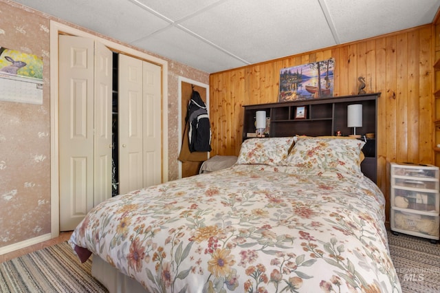 bedroom with a closet and wooden walls