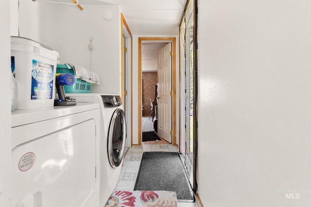 laundry area with washer and dryer and light tile patterned floors