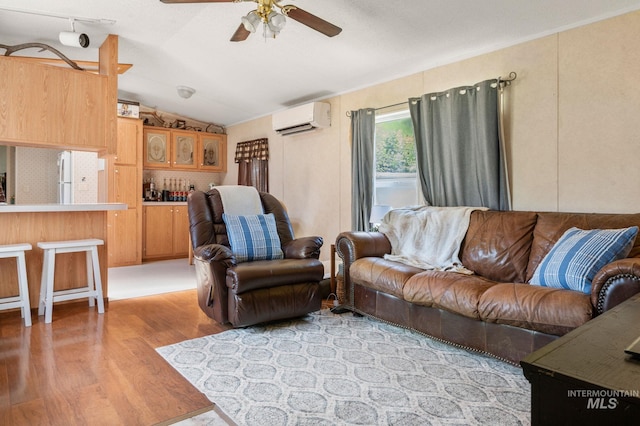 living room featuring a wall mounted AC, light wood finished floors, ceiling fan, and vaulted ceiling