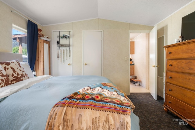 bedroom with lofted ceiling, ornamental molding, and dark colored carpet