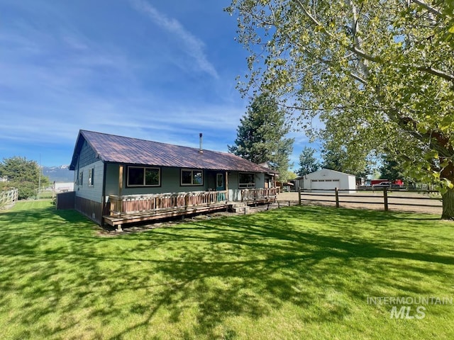 13974 Rustic Rd, Mccall, ID 83638 - back of house featuring a detached garage, a deck, metal roof, and an outbuilding