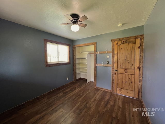 13974 Rustic Rd, Mccall, ID 83638 - unfurnished bedroom featuring dark wood-style flooring, a closet, a textured ceiling, a ceiling fan, and baseboards