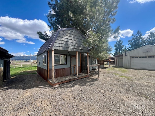 13974 Rustic Rd, Mccall, ID 83638 - view of front of home with an outbuilding, a gambrel roof, metal roof, and a garage