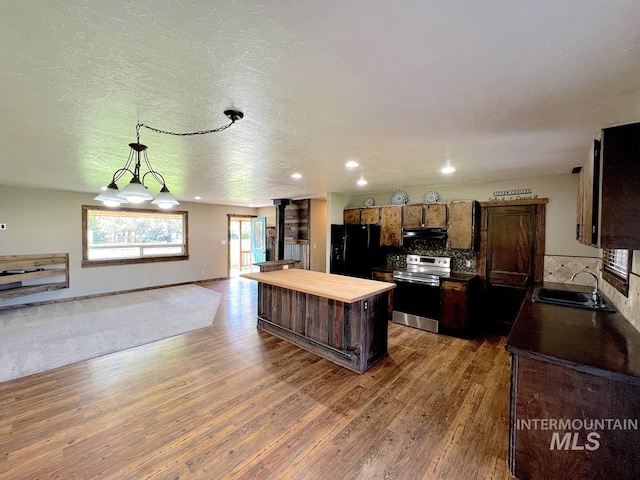13974 Rustic Rd, Mccall, ID 83638 - kitchen featuring stainless steel range with electric cooktop, freestanding refrigerator, a sink, exhaust hood, and a kitchen island