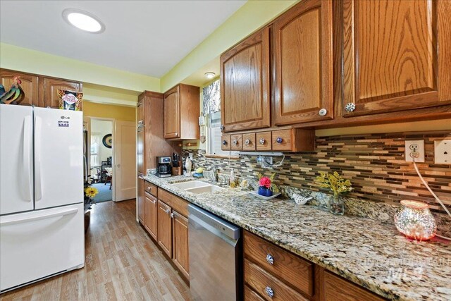 414 S 18th Ave, Caldwell, ID 83605 - kitchen featuring freestanding refrigerator, stainless steel dishwasher, a sink, and brown cabinetry