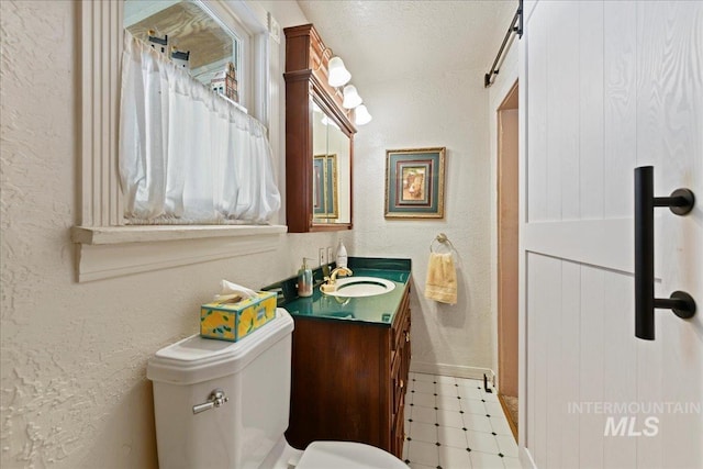 414 S 18th Ave, Caldwell, ID 83605 - bathroom featuring a textured wall, vanity, toilet, and baseboards