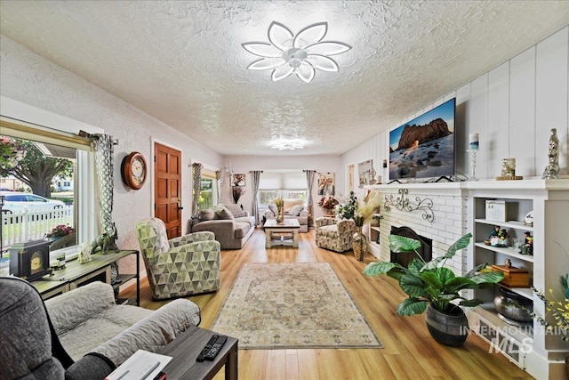 414 S 18th Ave, Caldwell, ID 83605 - living area featuring a textured ceiling, wood finished floors, and a brick fireplace