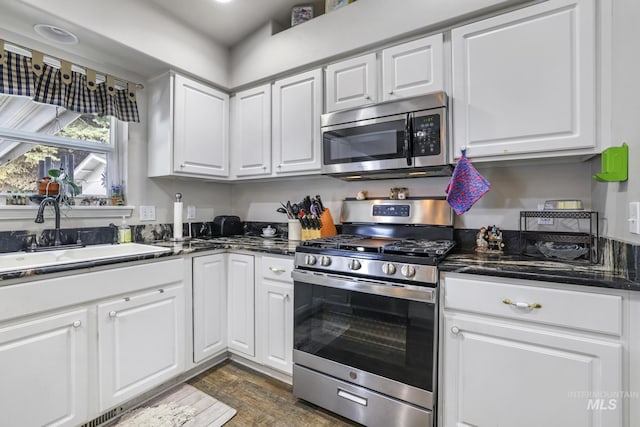265 Cedar Park Cir, Twin Falls, ID 83301 - kitchen with white cabinetry, dark wood-style flooring, a sink, and appliances with stainless steel finishes