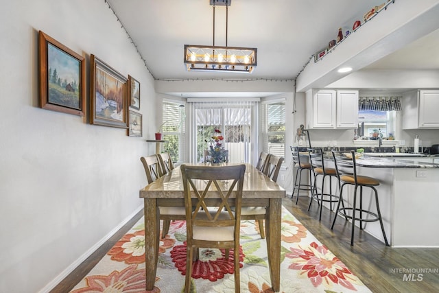 265 Cedar Park Cir, Twin Falls, ID 83301 - dining area with baseboards, an inviting chandelier, and dark wood-style flooring