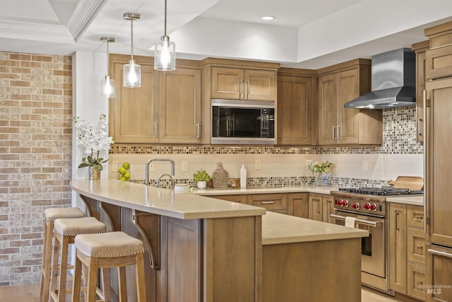 kitchen with built in microwave, light countertops, high end range, and wall chimney exhaust hood