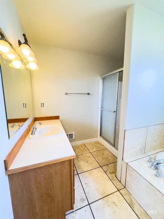 166 Eric Rd, Shoshone, ID 83352 - full bathroom with vanity, a stall shower, a garden tub, tile patterned floors, and baseboards
