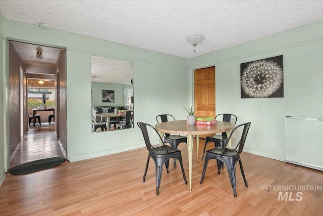 6426 W Fairfield Ave, Boise, ID 83709 - dining area with wood finished floors, a textured ceiling, and baseboards