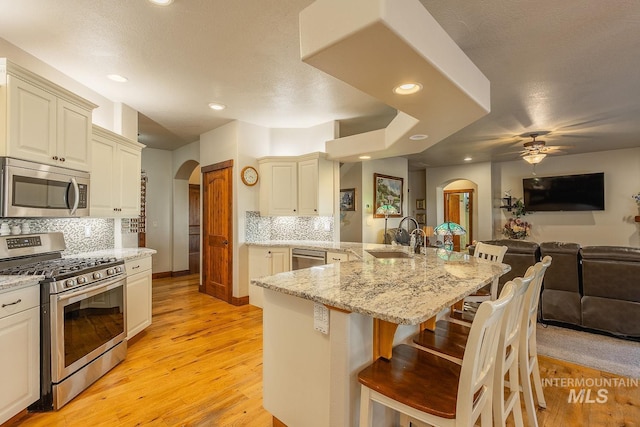 kitchen featuring cream cabinets, stainless steel appliances, a kitchen bar, and sink