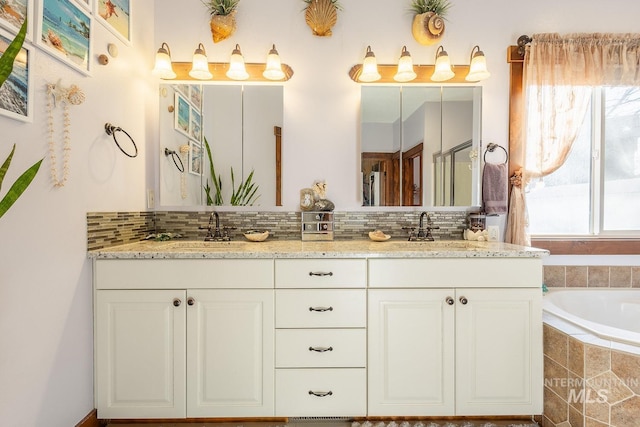 bathroom featuring vanity, tiled bath, and decorative backsplash