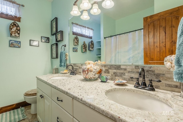 bathroom featuring tasteful backsplash, vanity, and toilet